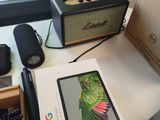 a box on a desk with a phone, speaker, and other items