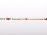 un gros plan d'un bracelet en or orné de pierres roses