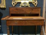 a wooden desk with a mirror and a clock on it