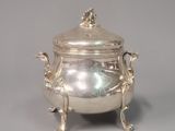 an antique silverplated teapot with a lid and handles on a stand