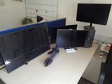 un bureau sur lequel sont posés deux écrans et un ordinateur portable