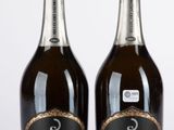 Deux bouteilles de champagne sont posées l'une à côté de l'autre sur une table.