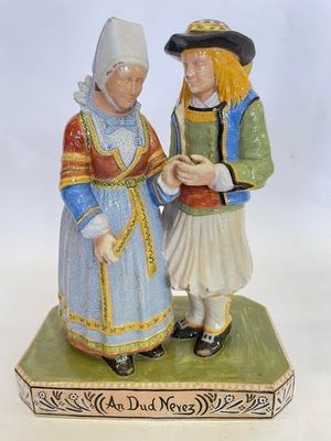 une figurine représentant un homme et une femme debout sur une caisse