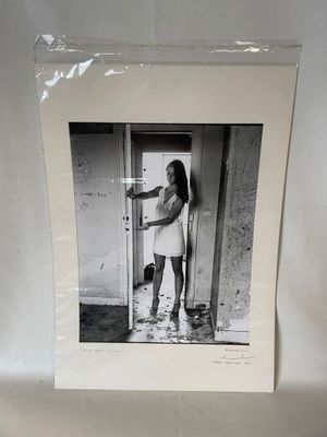photographie en noir et blanc d'une femme debout devant une porte