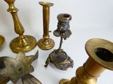 many different types of brass candlesticks on a table