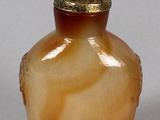 a small glass vase with a gold lid on a table