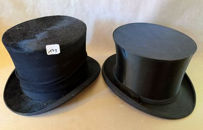 deux chapeaux haut-de-forme noirs posés sur une table