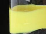 yellow liquid in a glass of water with a spoon sticking out of it