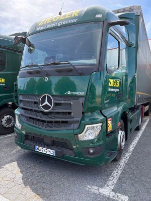 deux camions verts garés sur un parking