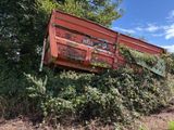 a red dump truck that is sitting in the middle of a field