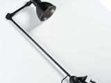 une lampe noire posée sur une table blanche