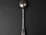 silver spoon on a black background with a textured surface
