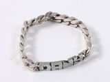 a close up of a silver bracelet with a name on it