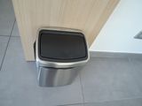 a trash can sitting on the floor next to a door