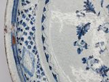 a blue and white plate with a flower design on it