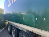 a green semi truck that is parked on the side of the road
