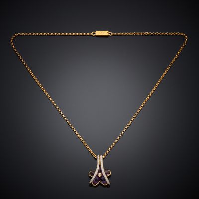 a gold necklace with a purple and white diamond pendant on a gold chain
