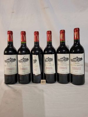 six bottles of wine are lined up on a table
