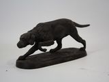 une statue représentant un chien qui court sur une planche