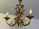 a gold chandelier hanging from the ceiling in a room