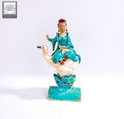 une figurine représentant une femme assise sur un cygne