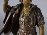 bronze statue of a man holding a shield and a sword