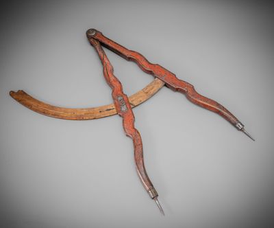 an old pair of scissors with a wooden handle on a gray background
