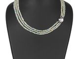 un collier composé de plusieurs rangs de perles de verre, muni d'un fermoir en argent, présenté sur un mannequin noir