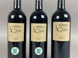 three bottles of red wine sitting next to each other on a table