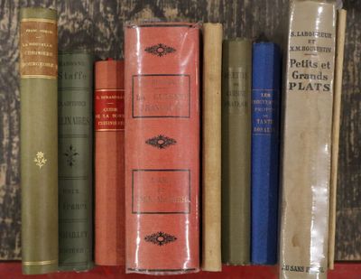 de nombreux livres rangés sur une étagère devant un mur en bois