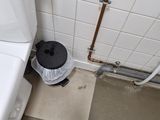 a white toilet and a black trash can in a bathroom
