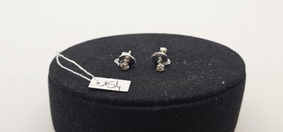 une paire de boucles d'oreilles en argent dans un coffret noir muni d'une étiquette