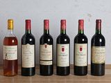 several bottles of wine are lined up on a wooden table