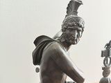 a statue of a man with a clock on a table