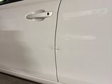 a white car parked in a parking lot with its door open