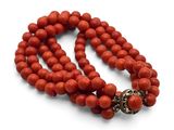 gros plan d'un collier de perles rouges sur fond blanc