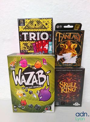 trois jeux de société posés les uns à côté des autres sur une table