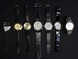 cinq modèles de montres différents sur un fond noir