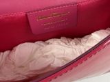 someone is holding a pink purse with a white shirt underneath it