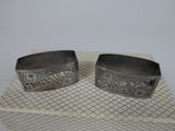 two silver cuff bracelets with engraved designs on them