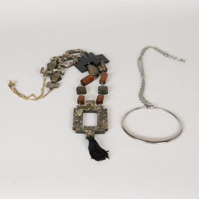 deux colliers et un bracelet sont posés sur une surface blanche