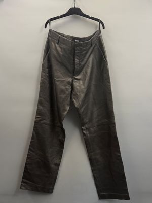 un pantalon en cuir marron suspendu à un cintre