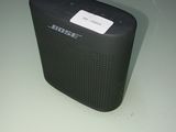 une petite enceinte noire posée sur une table