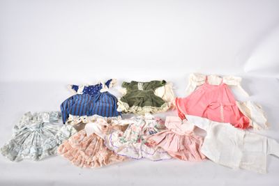 beaucoup de vêtements de bébé posés sur une surface blanche