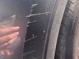 a hand that is touching a tire on the side of a car