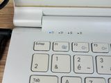 a white laptop computer sitting on a wooden desk