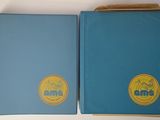two books are sitting on top of a white table