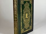 a green and gold book with gold trimming on the cover