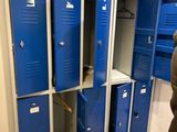 plusieurs casiers bleus dans une pièce, avec un homme debout à côté d'eux