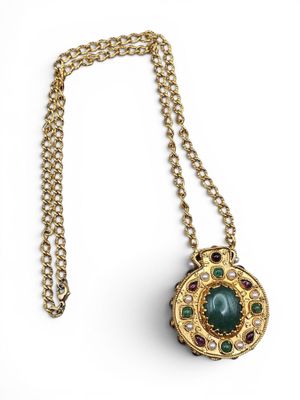 Gros plan sur un collier orné d'une pierre verte